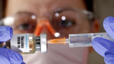 Pesquisadora segura frasco de vacina para covid-19 em teste Imagem: REUTERS/Dado Ruvic