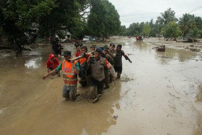Policiais evacuam as vtimas na aldeia de Radda aps inundaes que deixaram vrios mortos e dezenas de desaparecidos em Sulawesi, na Indonsia  Foto: Antara Foto/Indra via Reuters