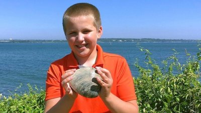 O garoto Cooper Monaco segura nas mos um molusco em tamanho gigante (comestvel e comum na costa atlntica dos EUA) Imagem: Todd McLeish/University of Rhode Island via AP