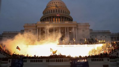 Exploso causada por uma munio da fora policial ilumina manifestantes pr-Trump que invadiram o Capitlio, em Washington Imagem: Leah Millis/Reuters